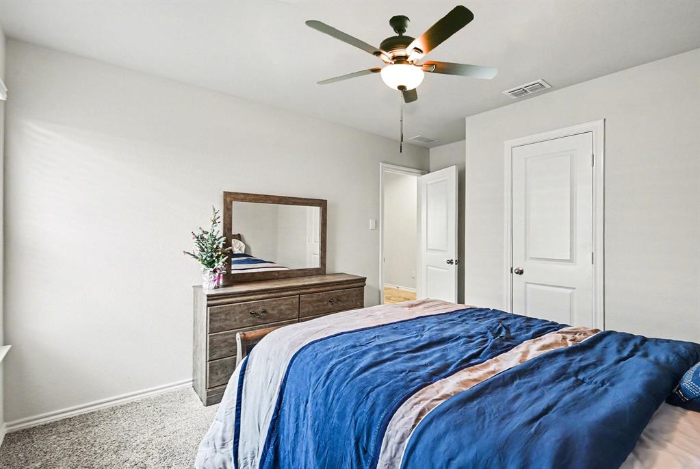 513 Bronze Circle West Springtown, TX 76082 - Photo 19 of 25 Carpeted bedroom featuring a ceiling fan with integrated lighting, white walls, and white trim