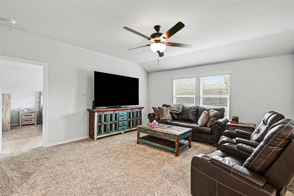 513 Bronze Circle West Springtown, TX 76082 - Photo 4 of 25 Carpeted living area featuring a ceiling fan with integrated lighting, multiple windows with blinds, and white painted walls