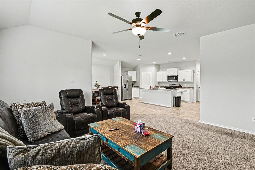 513 Bronze Circle West Springtown, TX 76082 - Photo 5 of 25 Spacious open-concept living area featuring high vaulted ceilings, a ceiling fan with integrated lighting, and plush carpeting