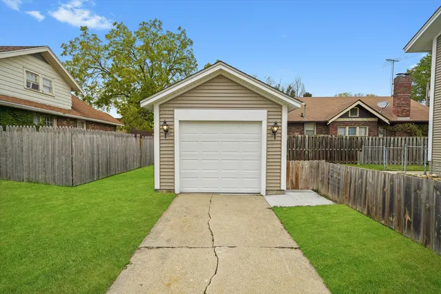 a view of a house with a small yard and a large tree
