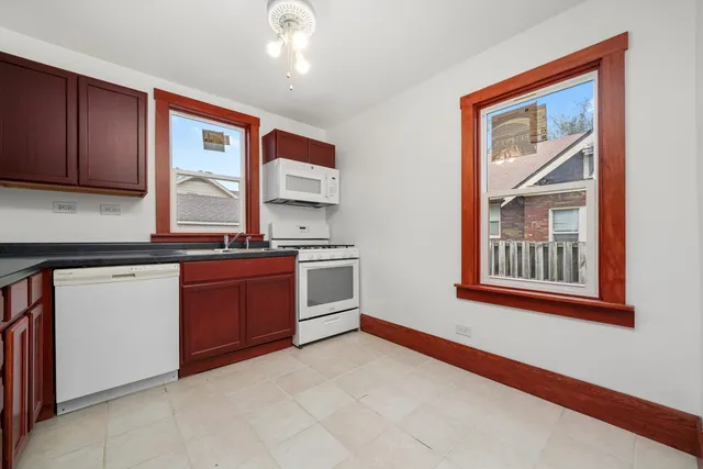 a kitchen with stainless steel appliances granite countertop a stove a sink and a microwave