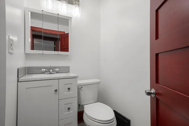 a bathroom with a toilet a sink and mirror