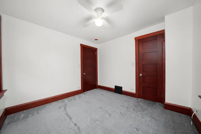 an empty room with a ceiling fan and a window