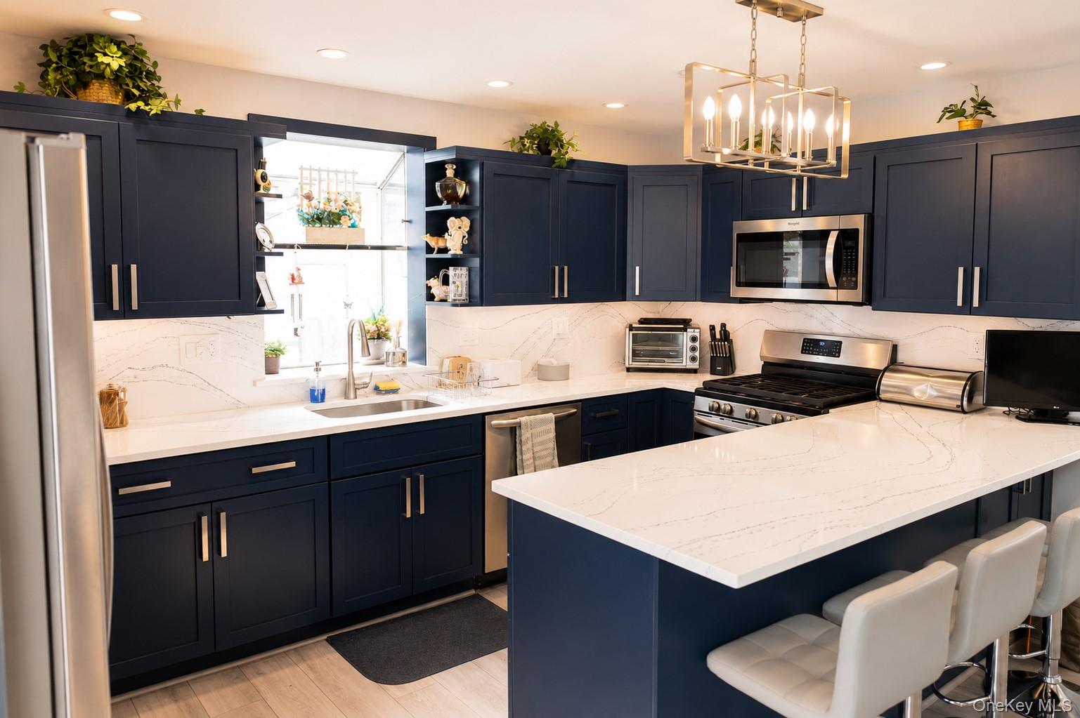 20 Carol Road Bethpage, NY 11714 - Photo 6 of 19 a kitchen with a refrigerator a microwave a sink and chairs