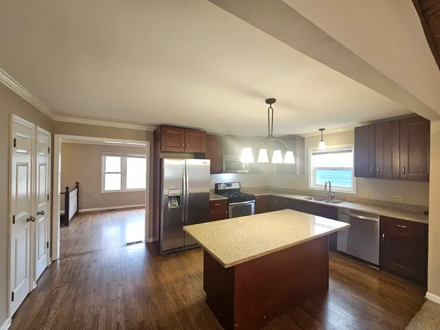 a large kitchen with stainless steel appliances a large counter top