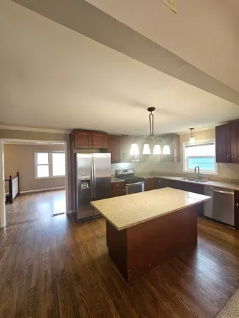 a large kitchen with stainless steel appliances a large counter top