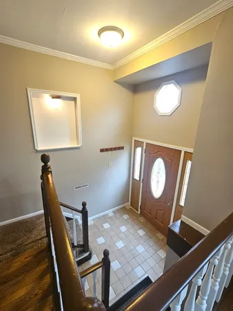 a view of a livingroom with wooden floor and staircase