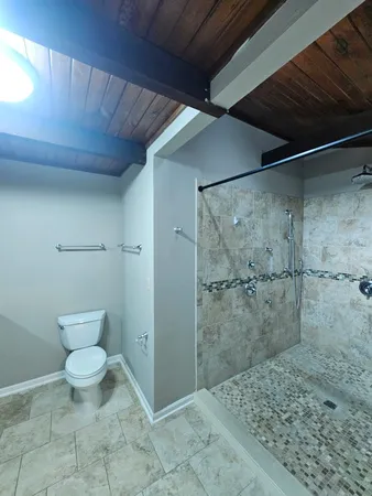 a bathroom with a granite countertop shower a toilet and a sink