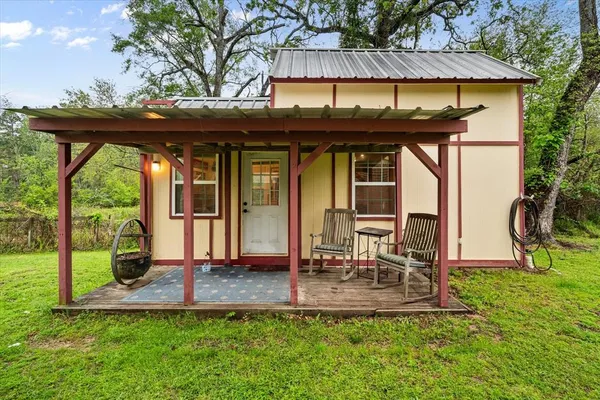 a view of a porch with a table and chairs under an umbrella