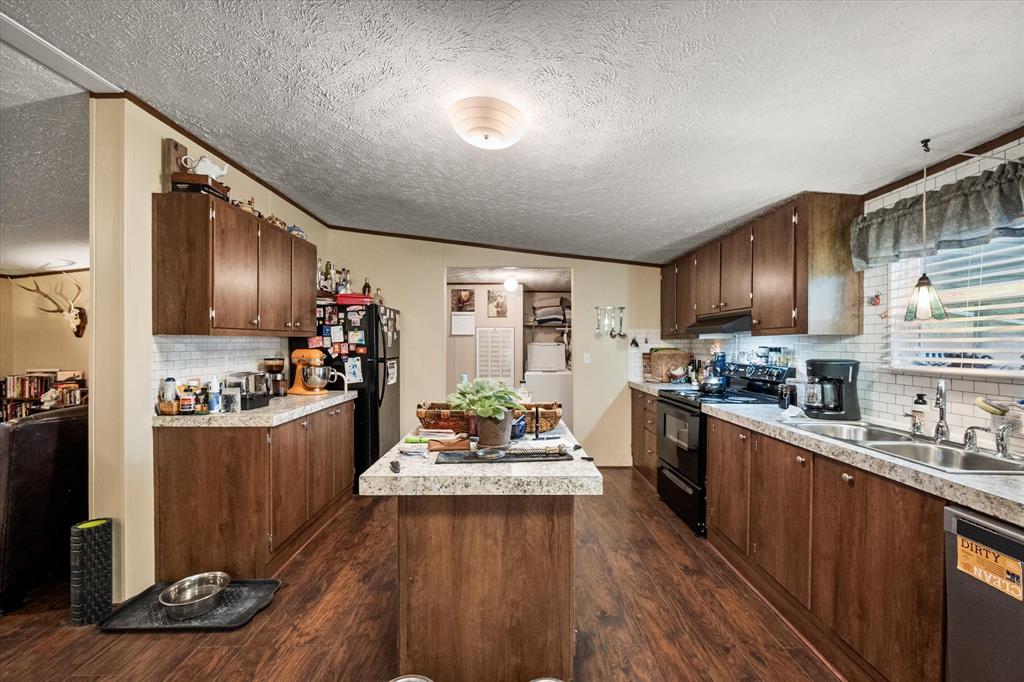 14036 Old Texaco Road Conroe, TX 77302 - Photo 26 of 40 a kitchen with refrigerator and wooden cabinets