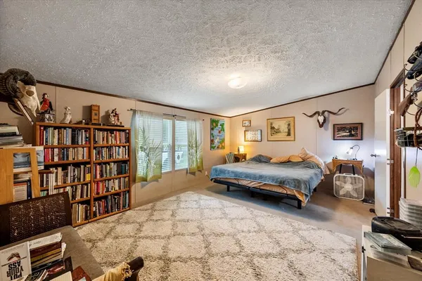 a spacious bedroom with a bed and a book shelf