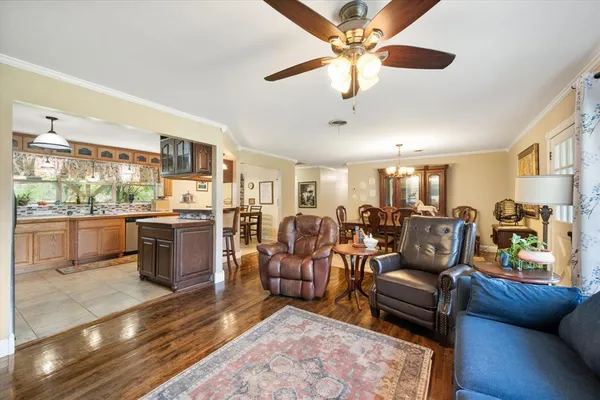 a living room with furniture kitchen view and a chandelier