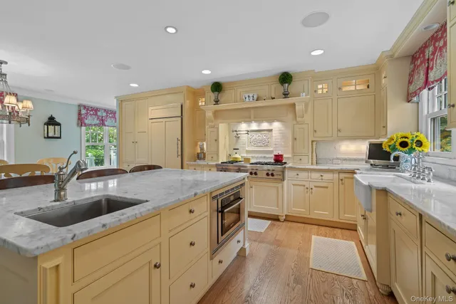 a kitchen with granite countertop a sink and white cabinets