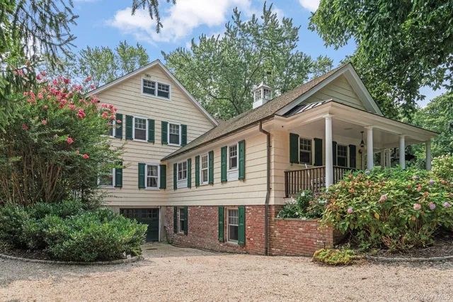 a front view of a house with a yard and potted plants