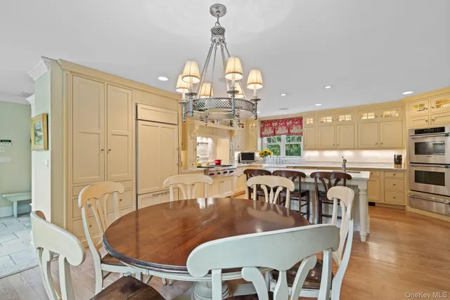 a dining room with furniture a chandelier and wooden floor
