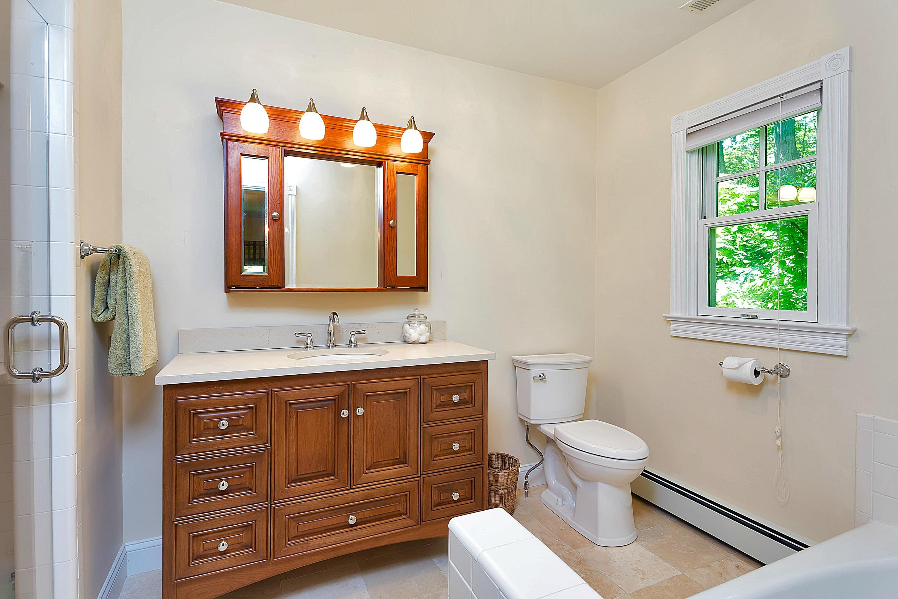 6 Wildcat Road Darien, CT 06820 - Photo 17 of 27 a bathroom with a toilet a sink a mirror a window and vanity