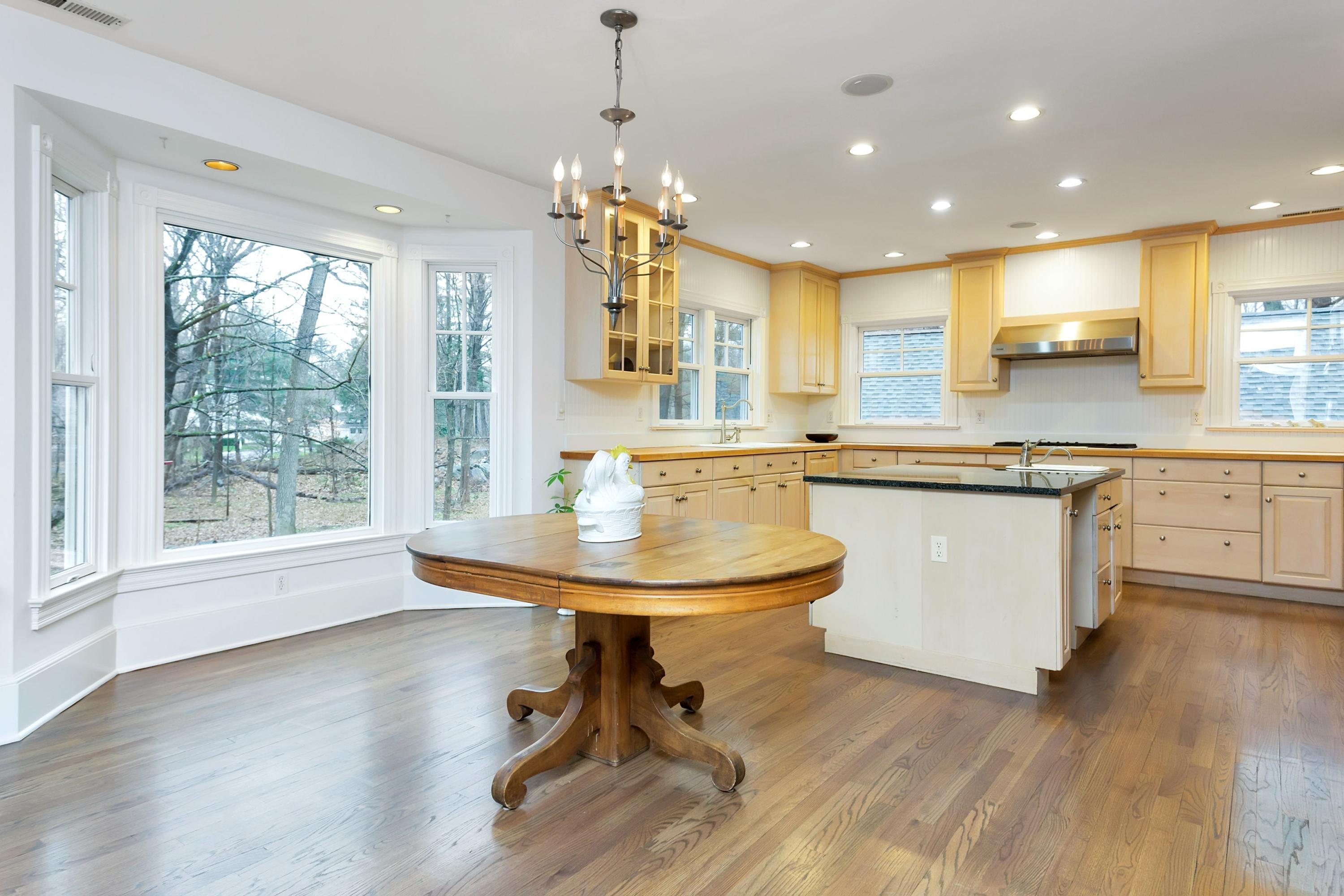 6 Wildcat Road Darien, CT 06820 - Photo 7 of 27 a kitchen with stainless steel appliances granite countertop a sink a stove a dining table and chairs