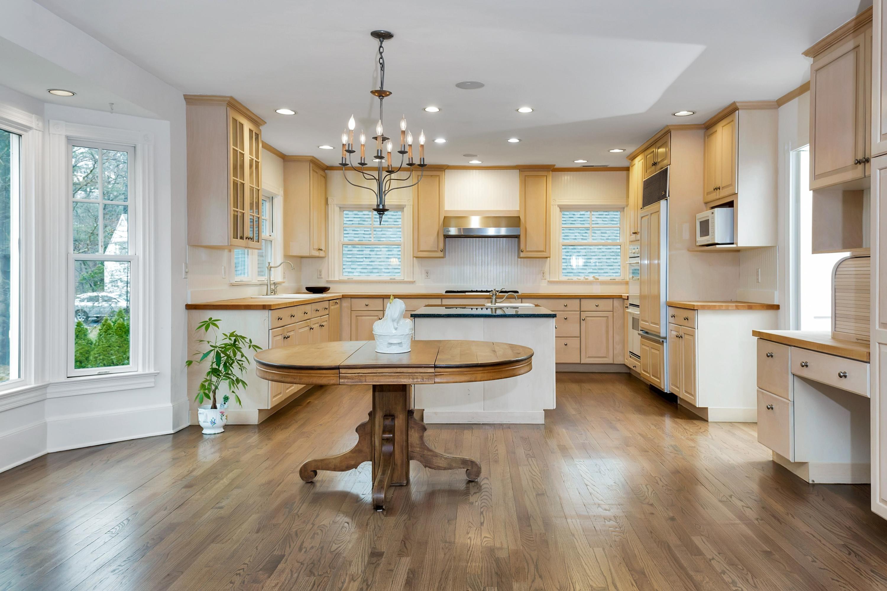 6 Wildcat Road Darien, CT 06820 - Photo 8 of 27 a kitchen with kitchen island a sink a stove a dining table and chairs