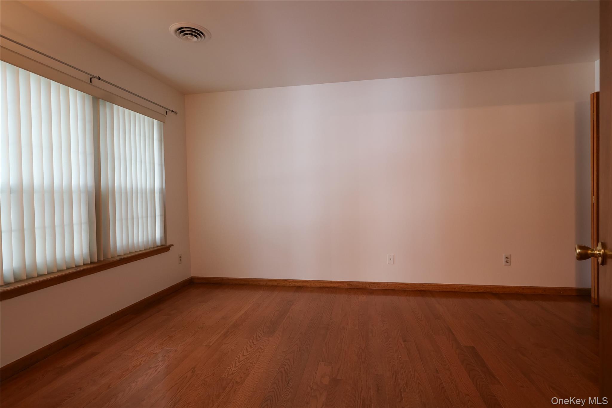 1306 Rosewood Court Highland Mills, NY 10930 - Photo 17 of 44 an empty room with wooden floor and windows