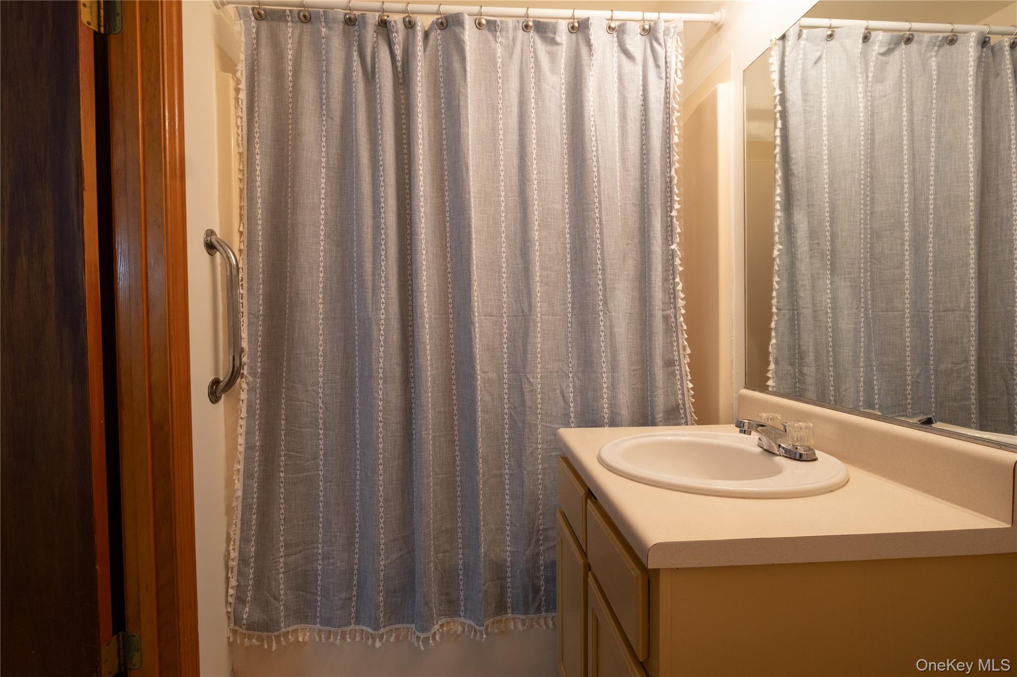 1306 Rosewood Court Highland Mills, NY 10930 - Photo 22 of 44 a bathroom with a sink a mirror and a shower curtain