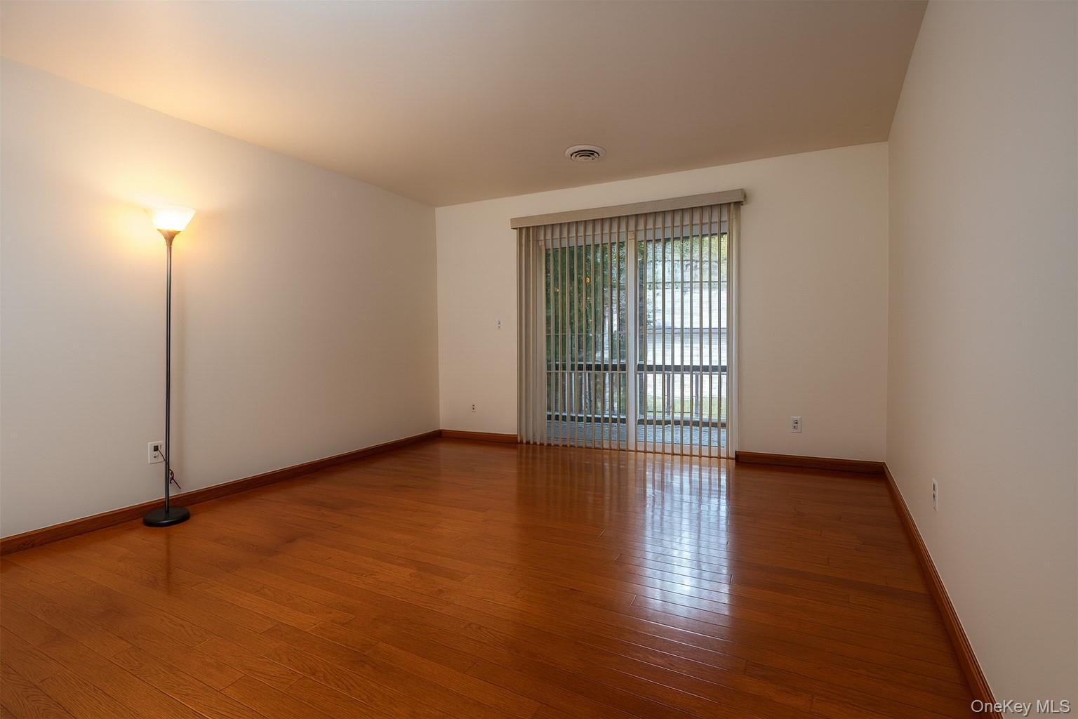 1306 Rosewood Court Highland Mills, NY 10930 - Photo 9 of 44 a view of an empty room with wooden floor and a window