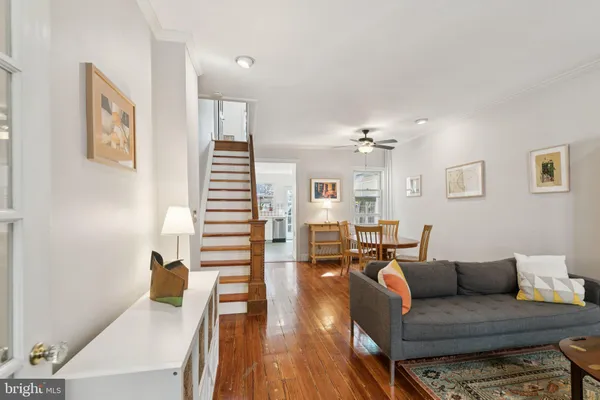 a living room with furniture a rug and a book shelf
