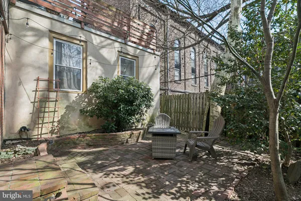 a backyard of a house with barbeque oven and plants