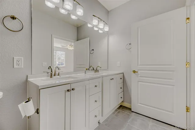 a spacious bathroom with a granite countertop sink a mirror and a shower