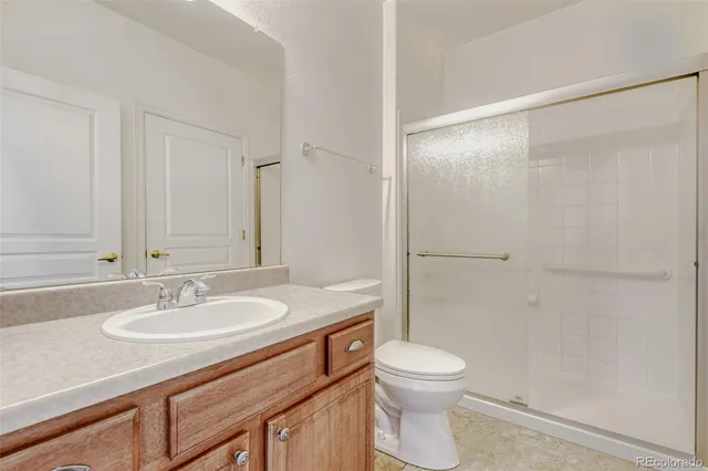 a bathroom with a granite countertop sink toilet a mirror and shower