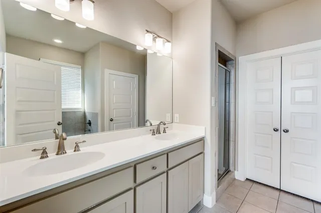 a bathroom with a double vanity sink a mirror and a shower