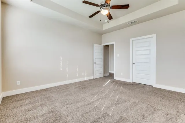 an empty room with closet and fan