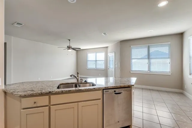 a kitchen with granite countertop a sink and a white cabinets