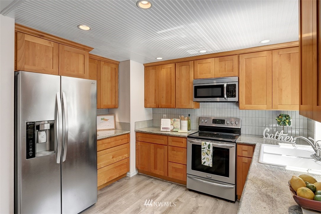 2 222nd Street Southwest Bothell, WA 98021 - Photo 6 of 29 a kitchen with stainless steel appliances a stove a sink a refrigerator cabinets and a window