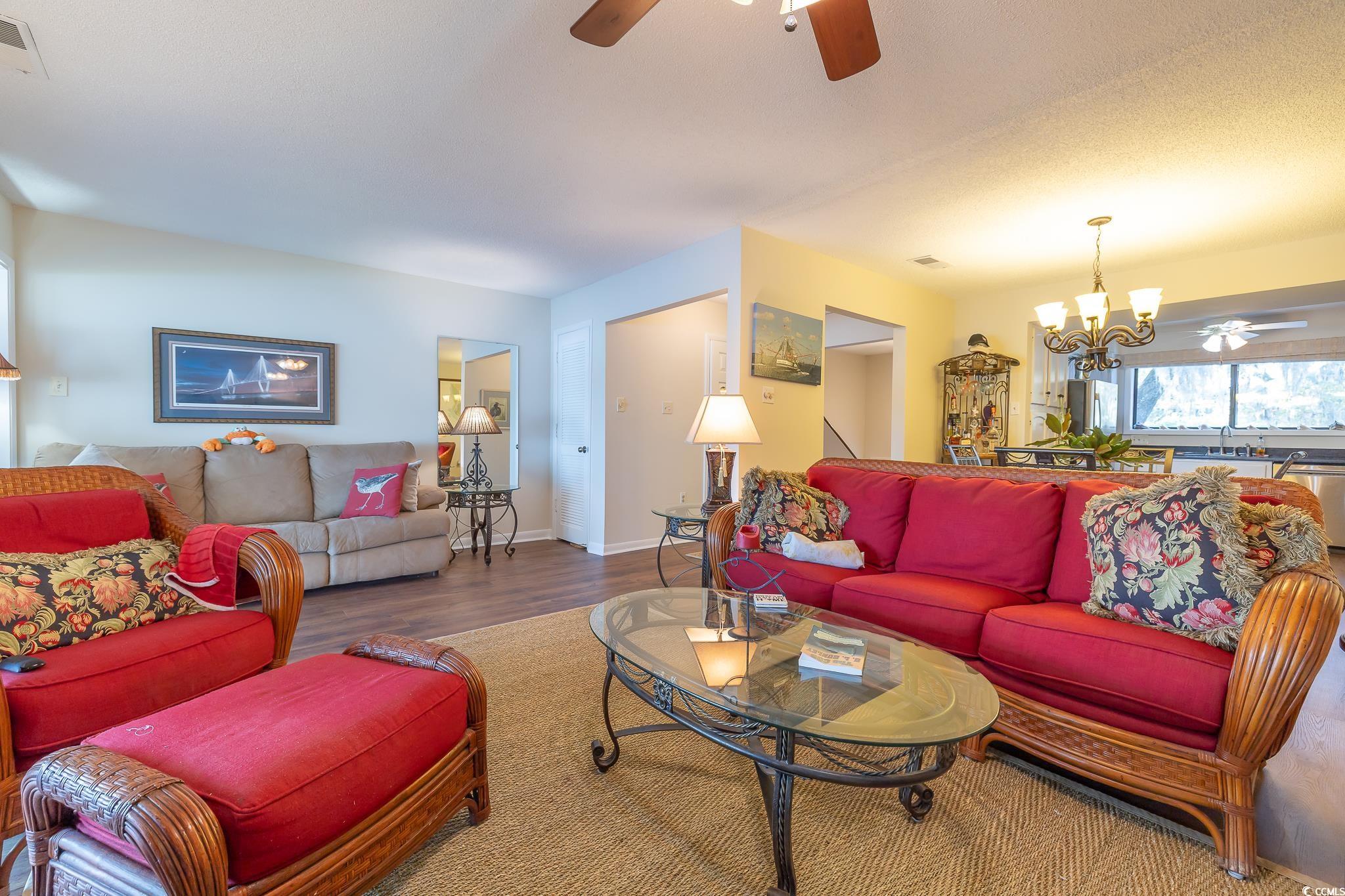 117 Finch Drive, Unit 272 Georgetown, SC 29440 - Photo 20 of 36 Living area featuring a ceiling fan, wood finished floors, and a chandelier
