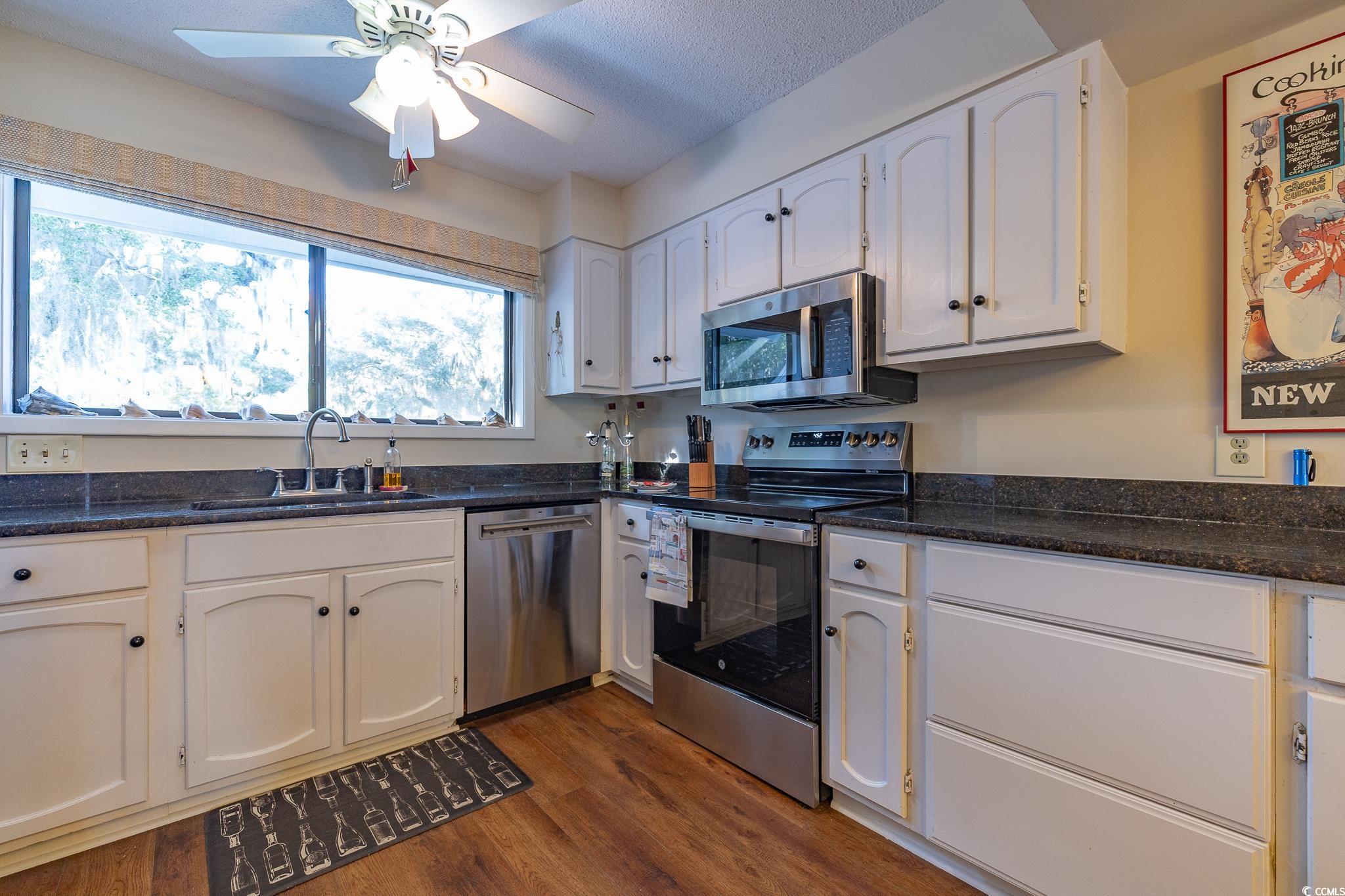 117 Finch Drive, Unit 272 Georgetown, SC 29440 - Photo 28 of 36 Kitchen with white cabinetry, stainless steel appliances, dark wood finished floors, dark stone countertops, and ceiling fan