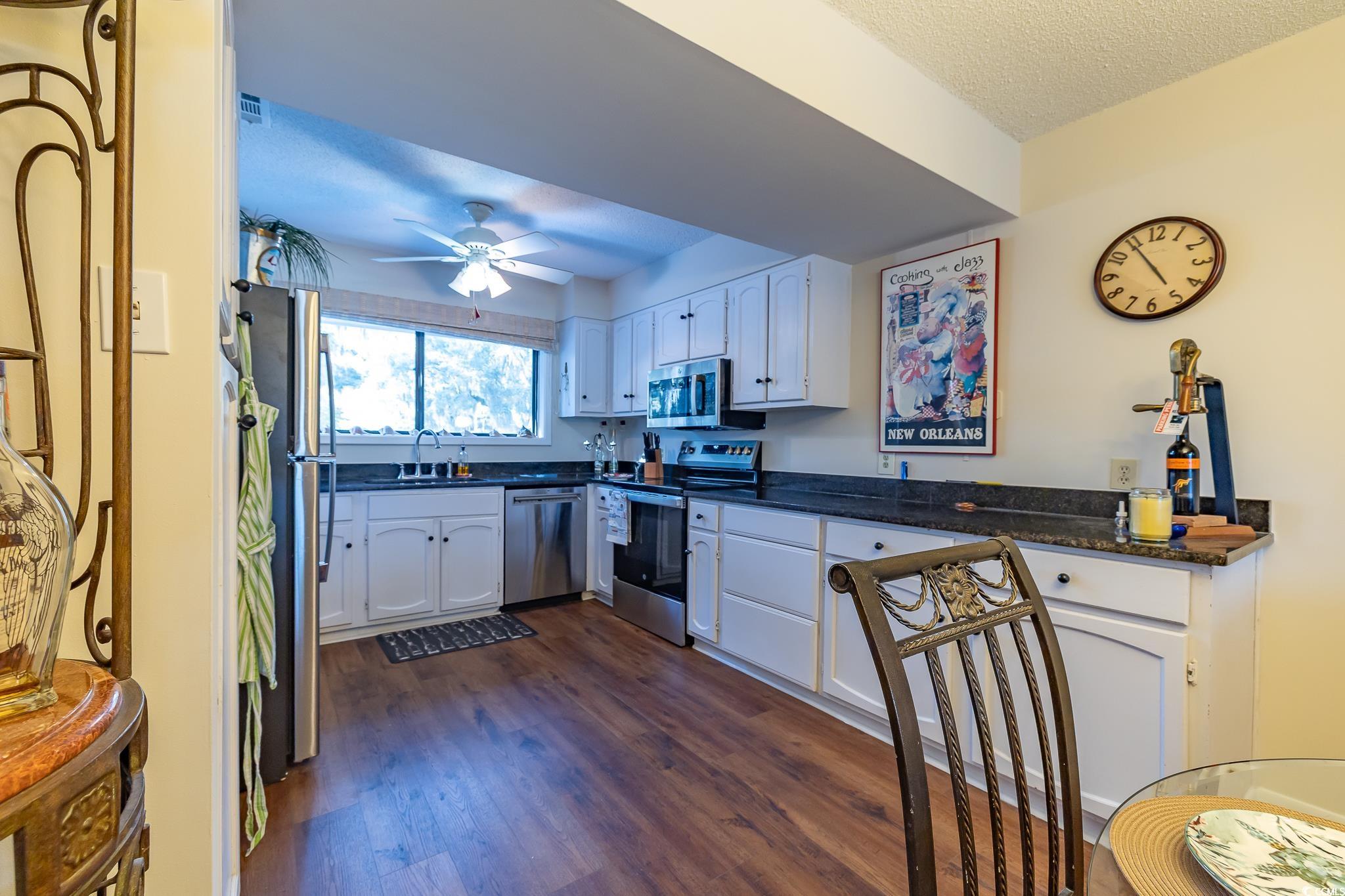 117 Finch Drive, Unit 272 Georgetown, SC 29440 - Photo 29 of 36 Kitchen with appliances with stainless steel finishes, white cabinets, dark wood-style flooring, a textured ceiling, and ceiling fan
