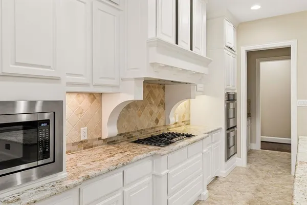 a kitchen with stainless steel appliances granite countertop a stove a microwave and a refrigerator