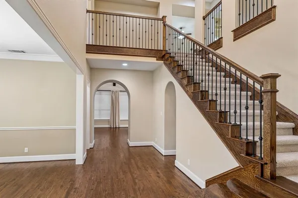 a view of staircase with wooden floor and white walls