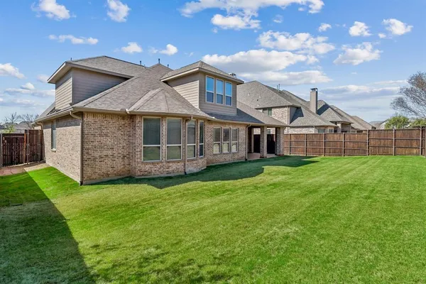 a view of a house with a big yard and large trees