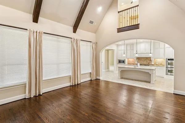 a view of a kitchen with wooden floor and a window