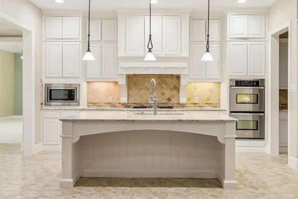 a kitchen with stainless steel appliances kitchen island sink refrigerator and microwave
