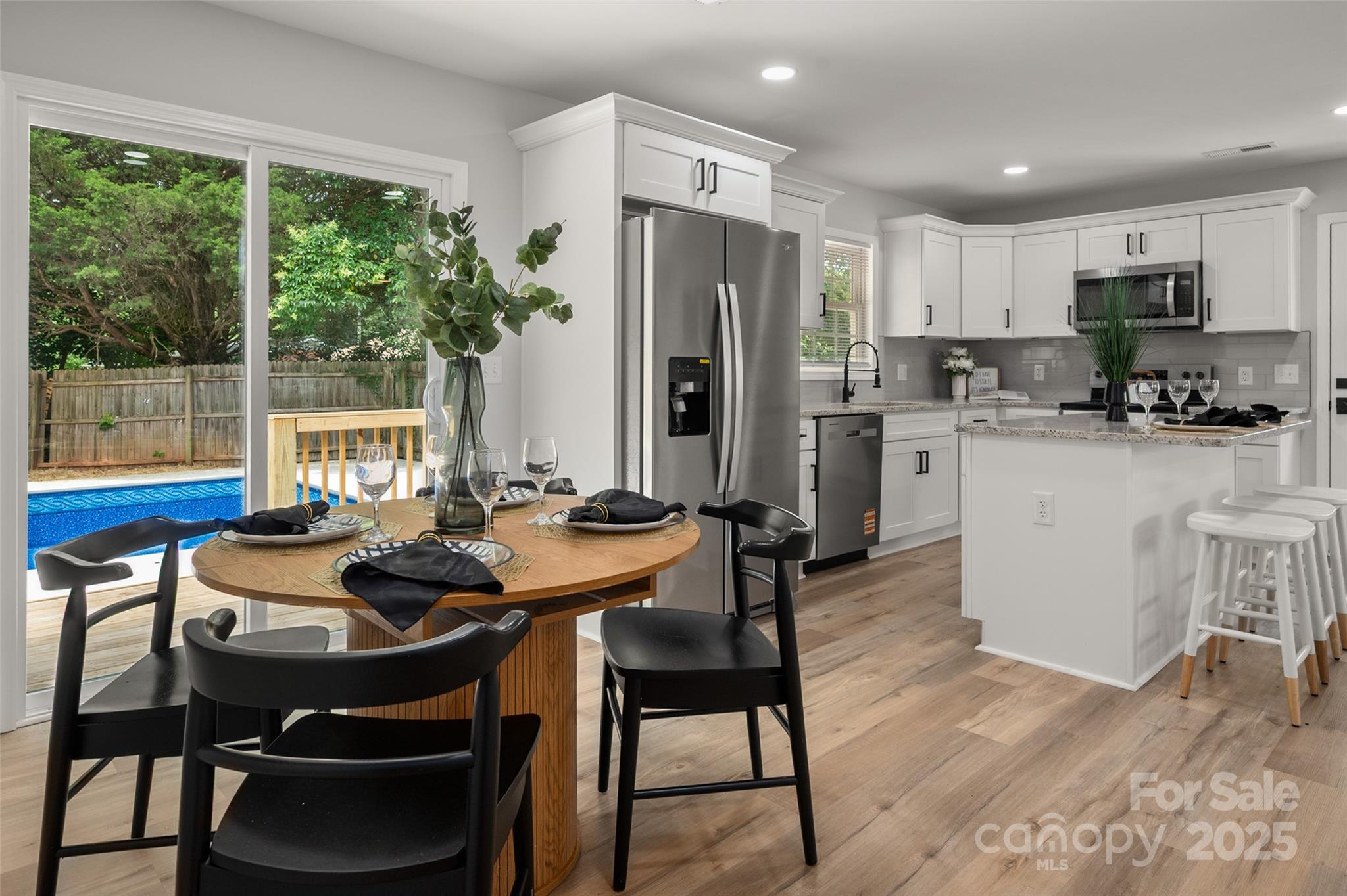 756 Logan Street Mooresville, NC 28115 - Photo 13 of 30 a kitchen with a table chairs refrigerator and microwave