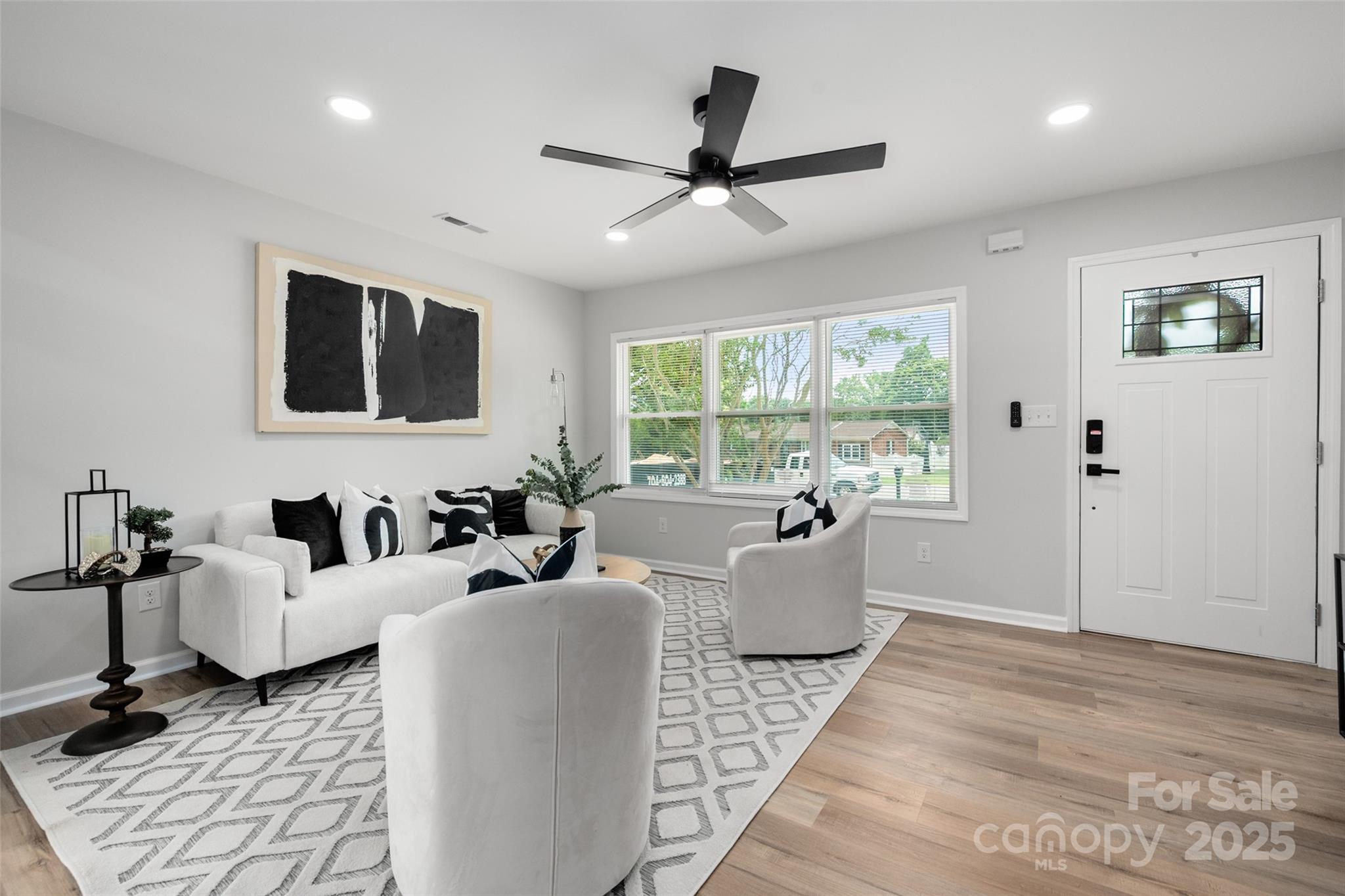 756 Logan Street Mooresville, NC 28115 - Photo 3 of 30 a living room with furniture floor to ceiling window and a flat screen tv