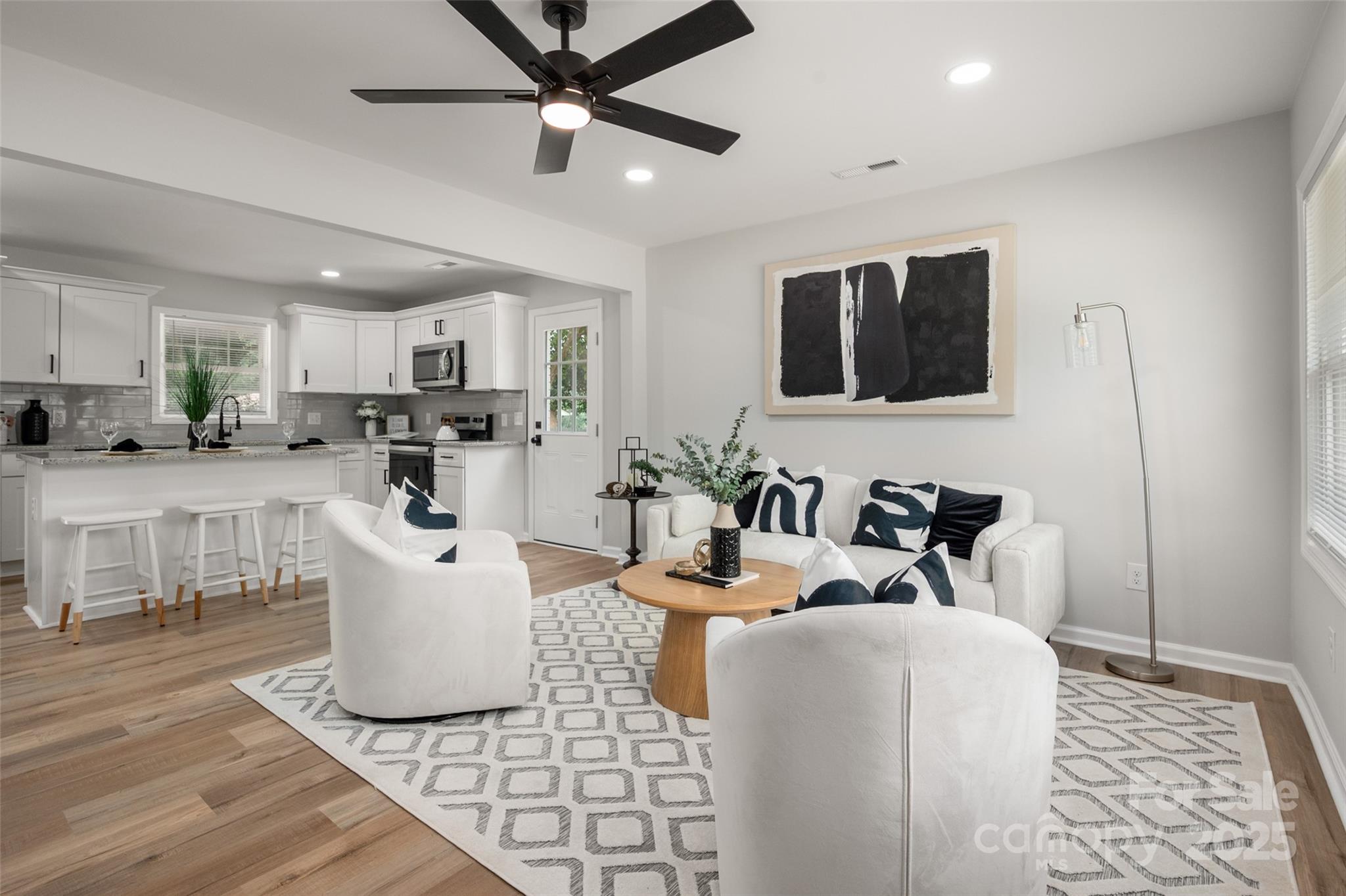 756 Logan Street Mooresville, NC 28115 - Photo 5 of 30 a living room with furniture a flat screen tv and kitchen view