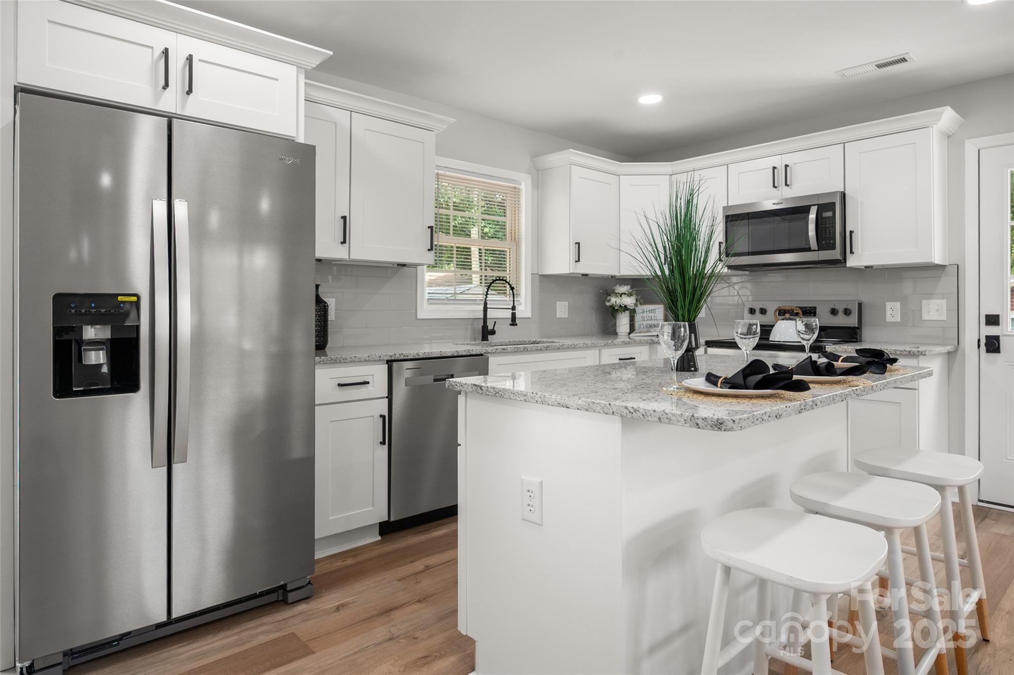 756 Logan Street Mooresville, NC 28115 - Photo 8 of 30 a kitchen with stainless steel appliances a refrigerator sink and microwave