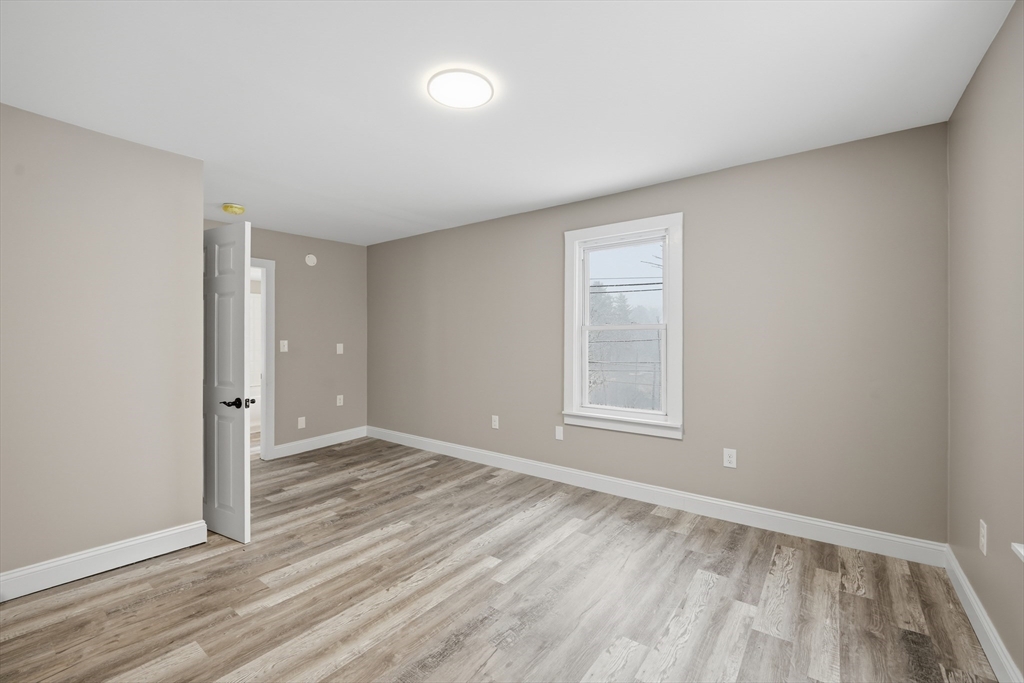 1209 Brimfield Road Warren, MA 01083 - Photo 26 of 41 an empty room with wooden floor and windows