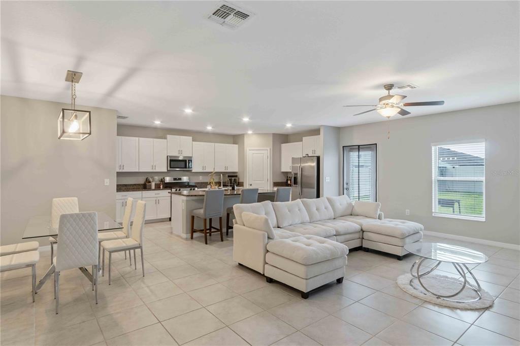 9440 Lemon Drop Loop Sun City Center, FL 33573 - Photo 8 of 55 a living room with furniture and a dining table with kitchen view