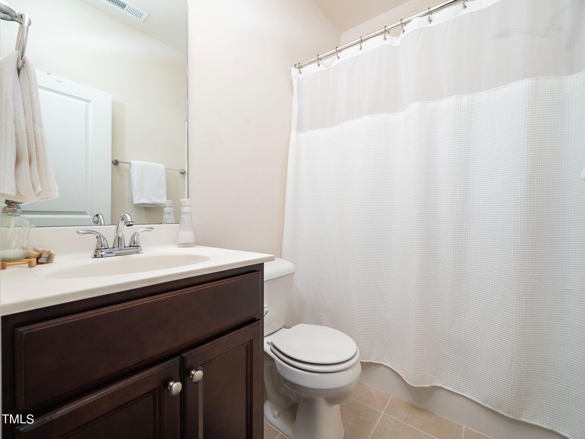 8804 Commons Townes Drive Raleigh, NC 27616 - Photo 18 of 21 a bathroom with a sink vanity mirror and toilet