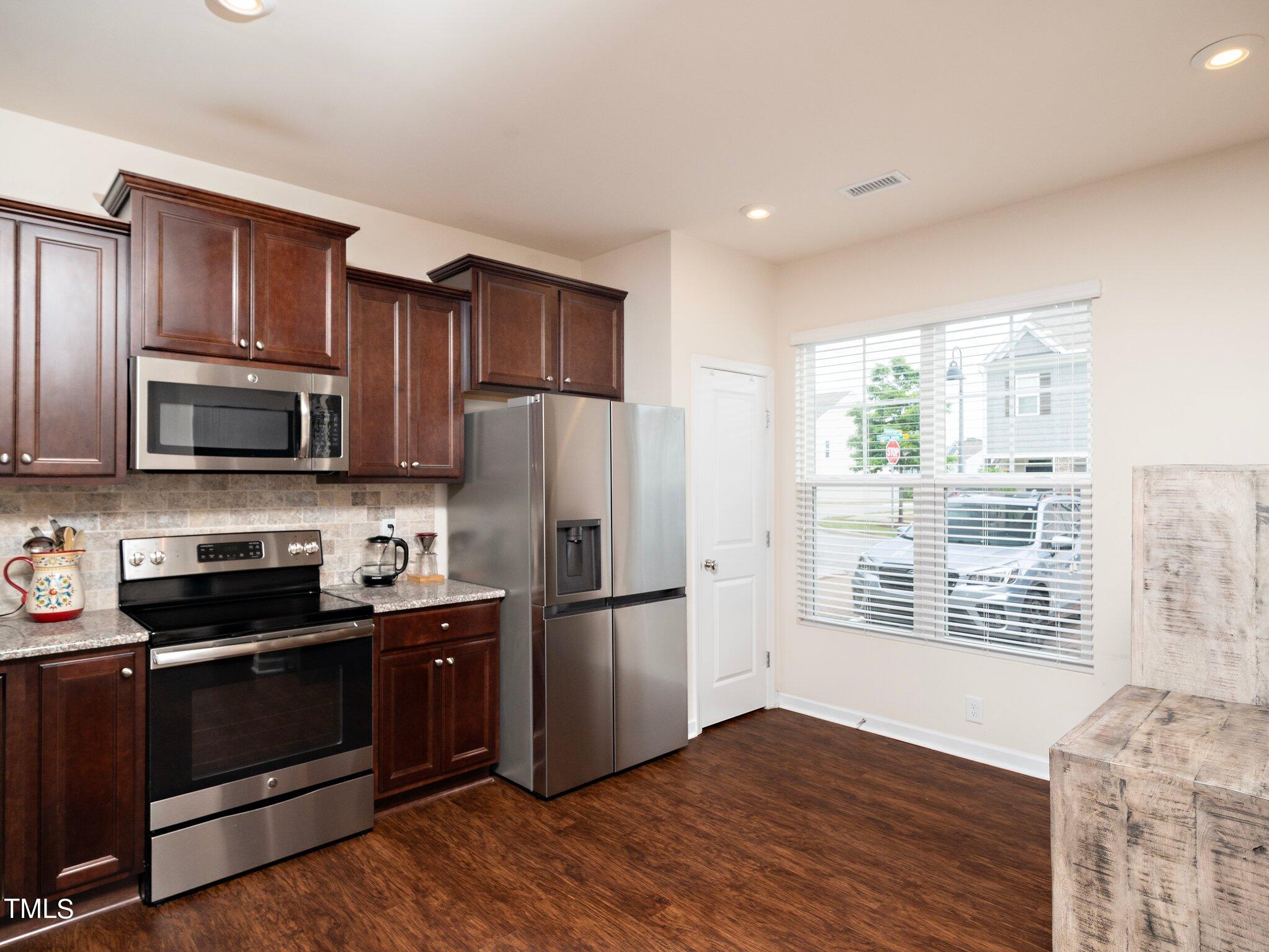 8804 Commons Townes Drive Raleigh, NC 27616 - Photo 5 of 21 a kitchen with granite countertop a refrigerator stove and microwave