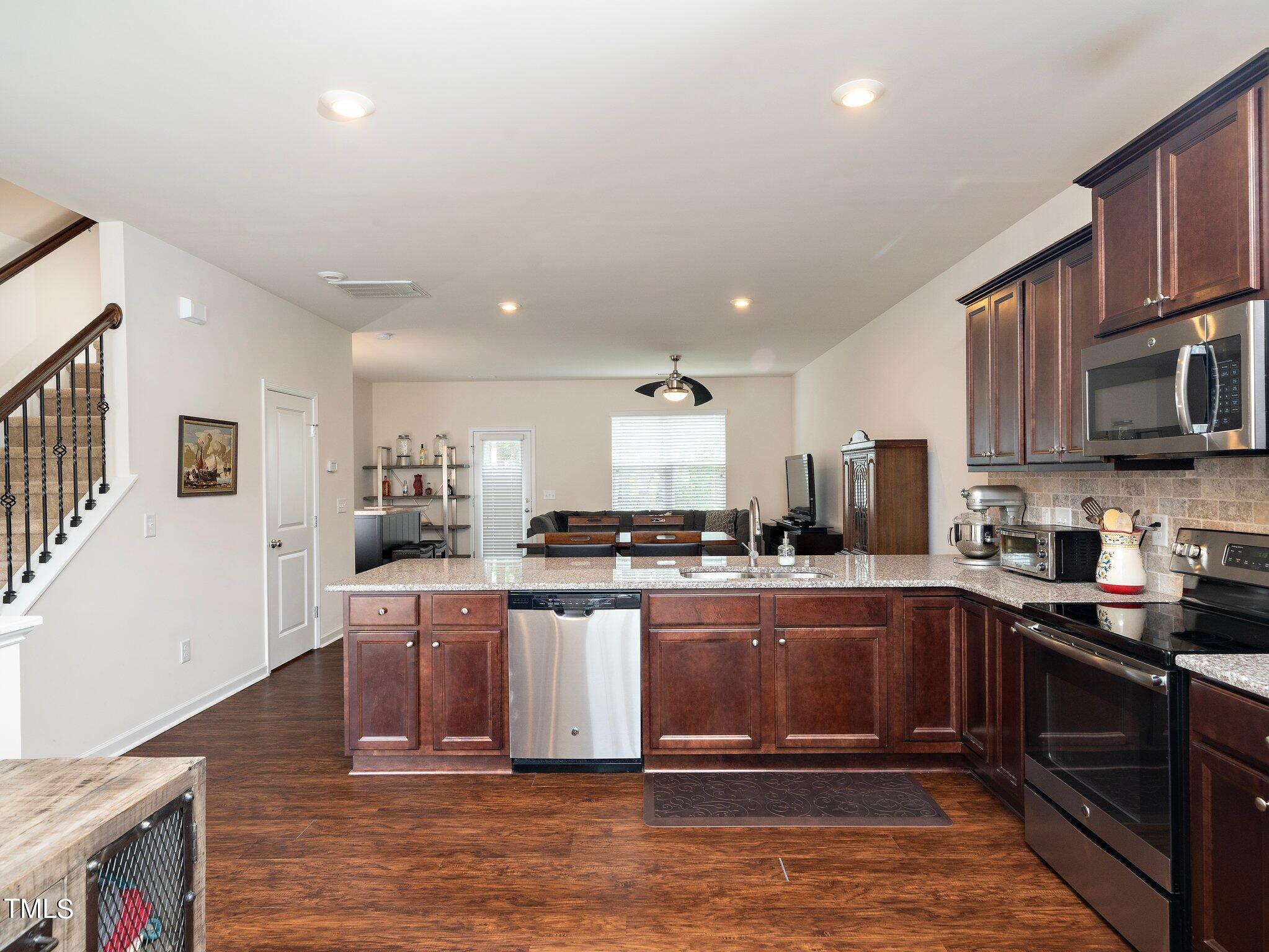 8804 Commons Townes Drive Raleigh, NC 27616 - Photo 6 of 21 a kitchen with stainless steel appliances granite countertop a stove top oven a sink a counter space and cabinets